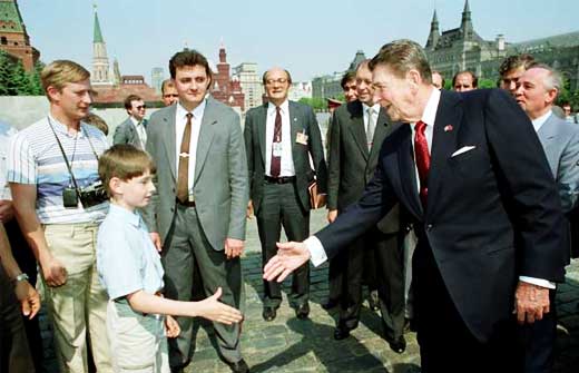In May 1988, President Ronald Reagan was in Moscow and on a walkabout in the Red Square, he met 'tourists' which included the man with the camera around his neck standing behind the boy – Vladimir Vladimirovich Putin, a KGB agent